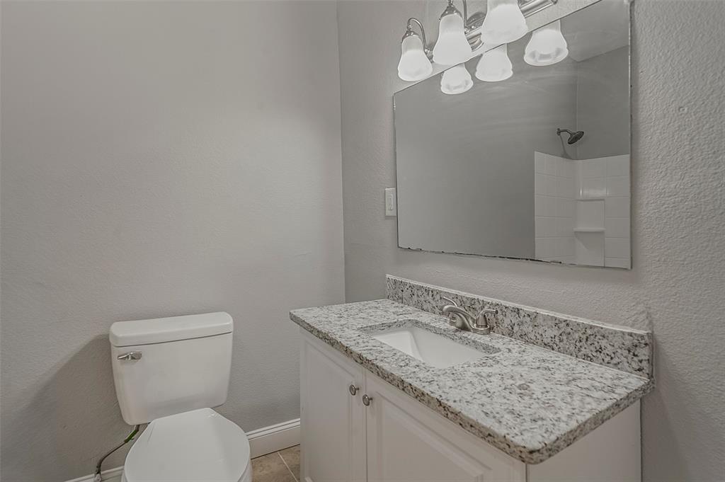 306 North Front Street Savoy, TX 75479 - Photo 21 of 27 a bathroom with a granite countertop sink and a toilet