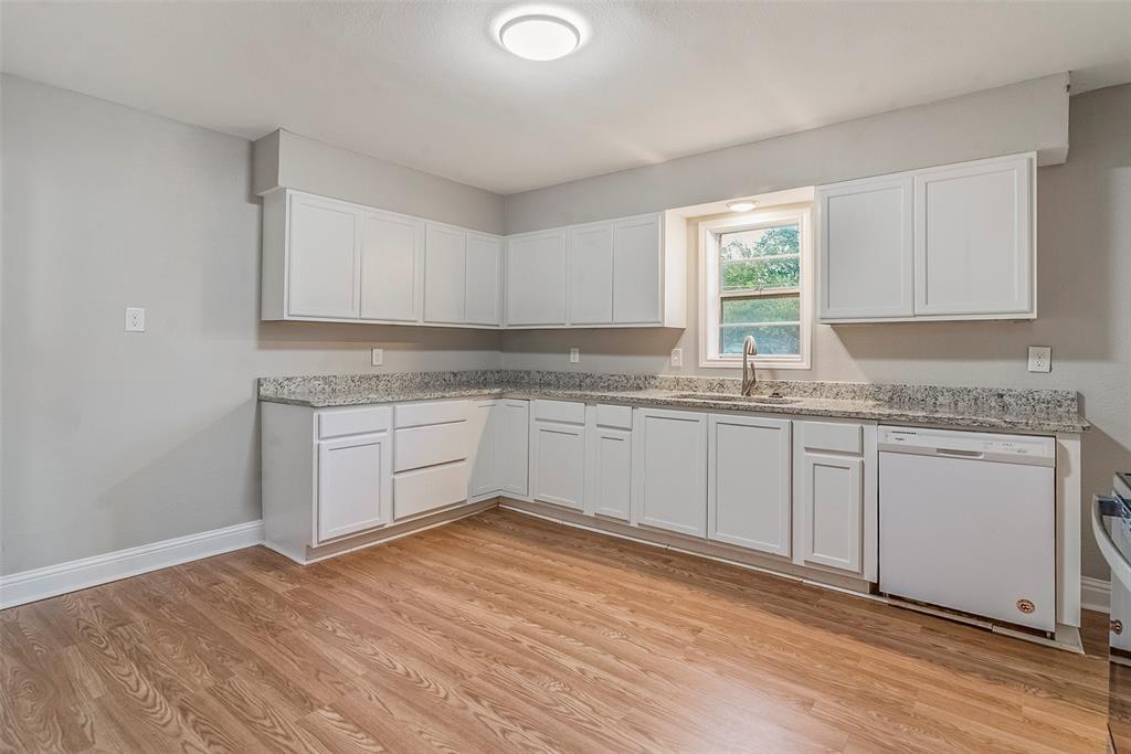 306 North Front Street Savoy, TX 75479 - Photo 7 of 19 a kitchen with granite countertop white cabinets and white appliances