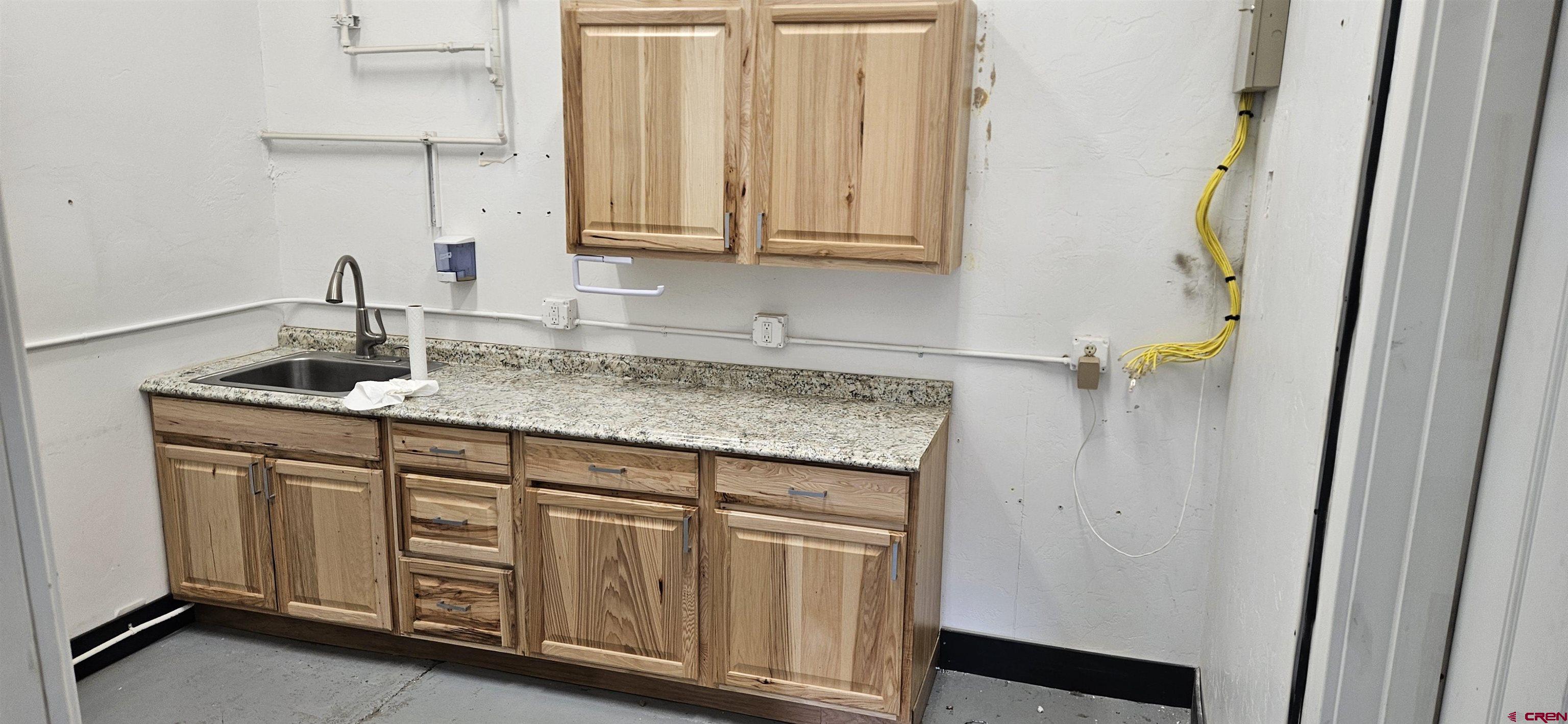 158 Liddell Drive, Unit B Ridgway, CO 81432 - Photo 8 of 11 a sink with granite countertop cabinets and a sink