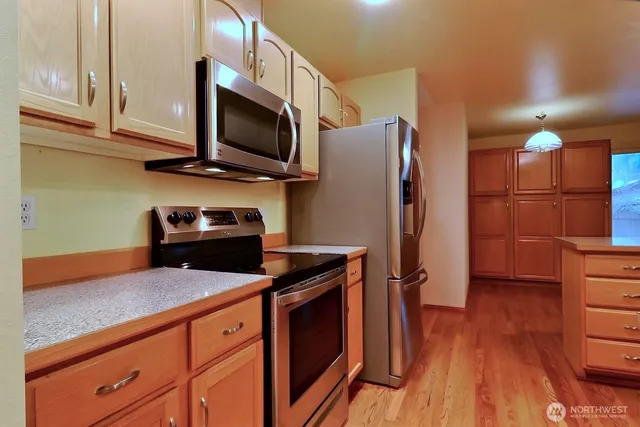a kitchen with stainless steel appliances granite countertop a refrigerator stove and microwave