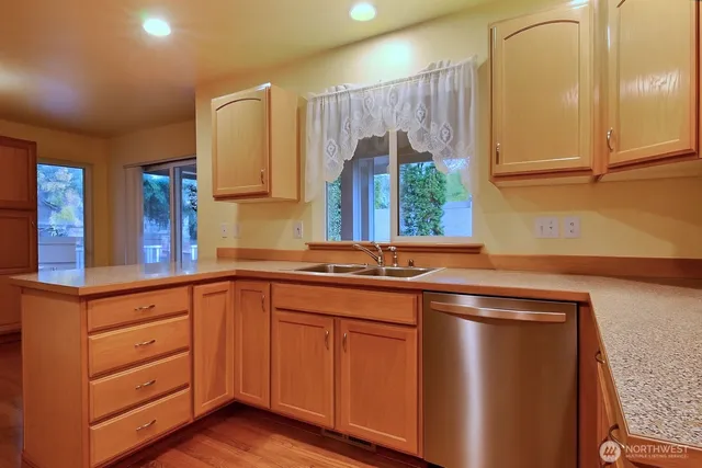 a kitchen with stainless steel appliances granite countertop a sink a stove and a refrigerator