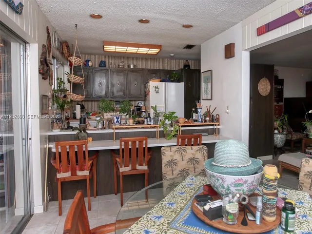 a room with stainless steel appliances a table and chairs