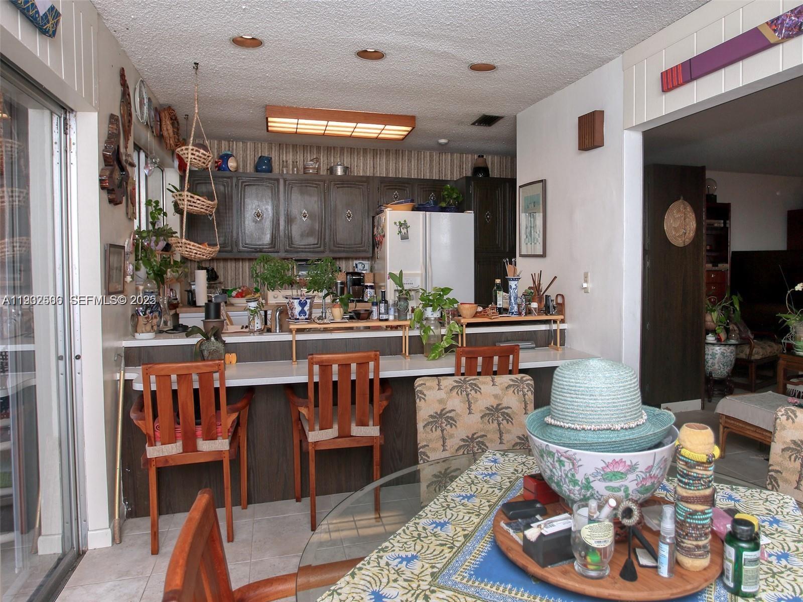 6918 Holly Road Miami Lakes, FL 33014 - Photo 3 of 10 a room with stainless steel appliances a table and chairs