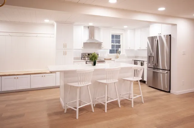 a kitchen with granite countertop a refrigerator stove microwave and cabinets