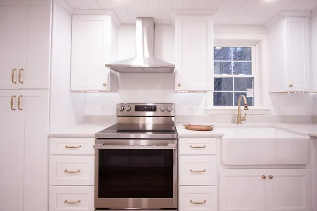 a kitchen with white cabinets and white appliances