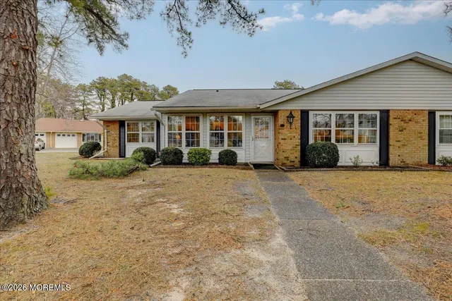 a view of a white house with a garden space