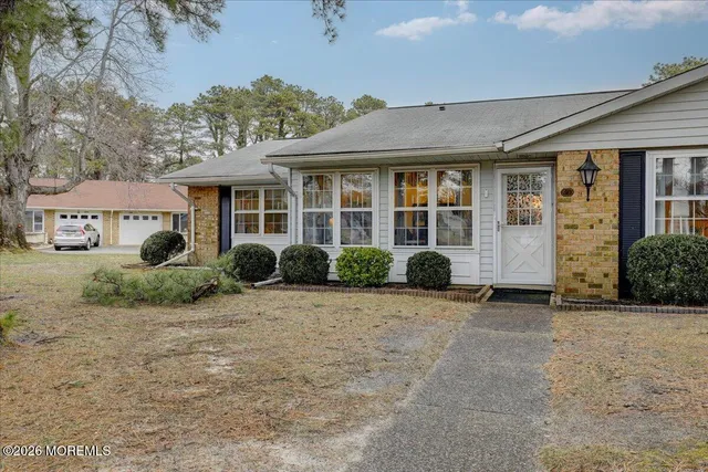 a view of a house with a yard and large tree