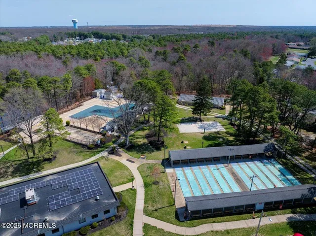 an aerial view of a house with swimming pool and outdoor seating