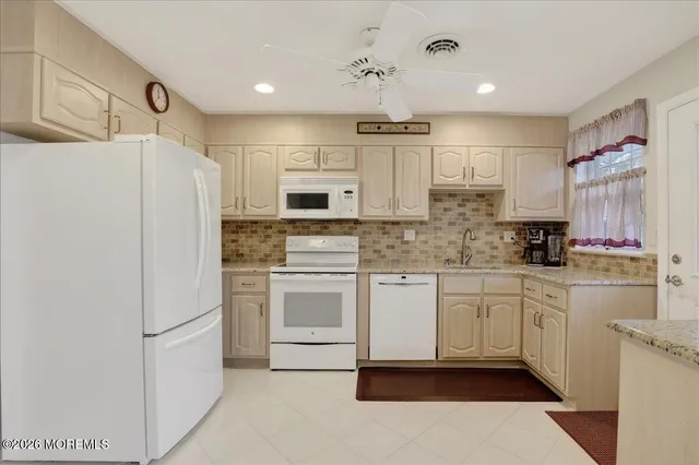 a kitchen with white cabinets and white appliances