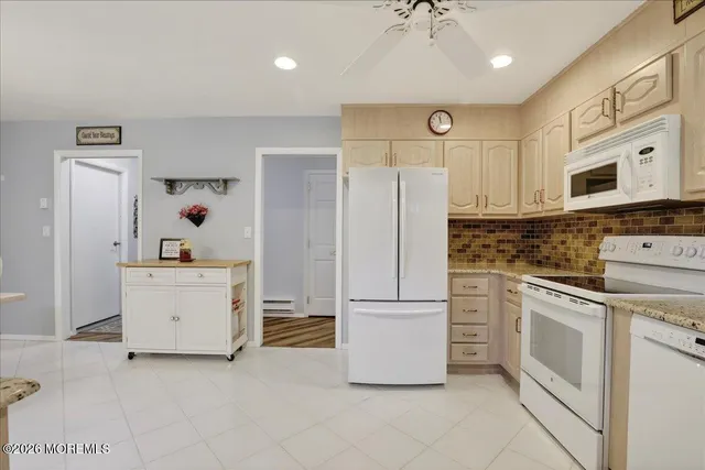 a kitchen with white cabinets and white appliances