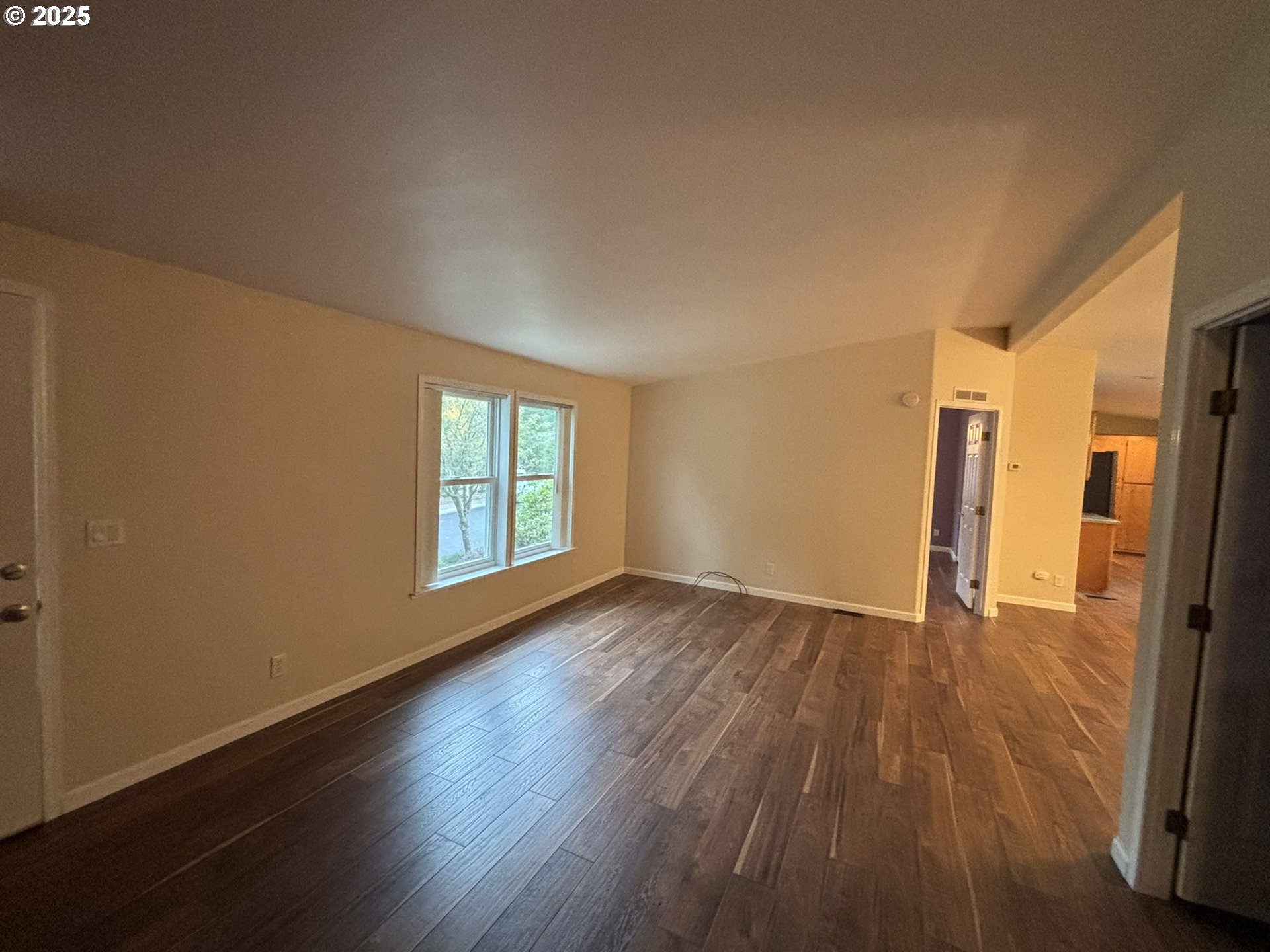 325 Jonathan Lane Florence, OR 97439 - Photo 4 of 37 a view of an empty room with wooden floor and a window