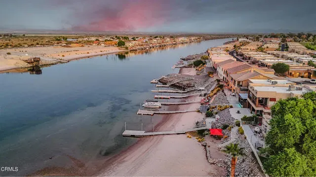 an aerial view of ocean and residential houses with outdoor space