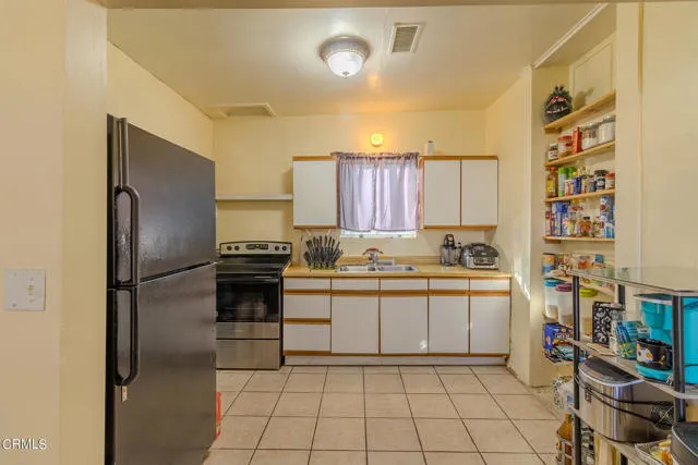 813 West Broadway Street Needles, CA 92363 - Photo 7 of 27 a kitchen with stainless steel appliances a refrigerator sink and cabinets