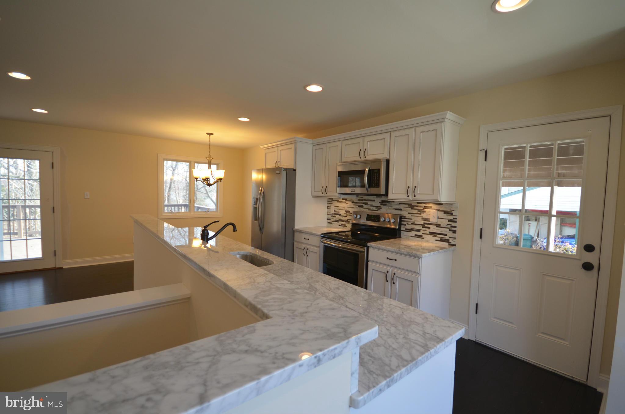6405 Darwin Road Laurel, MD 20707 - Photo 2 of 20 a kitchen with stainless steel appliances granite countertop a sink stove and refrigerator