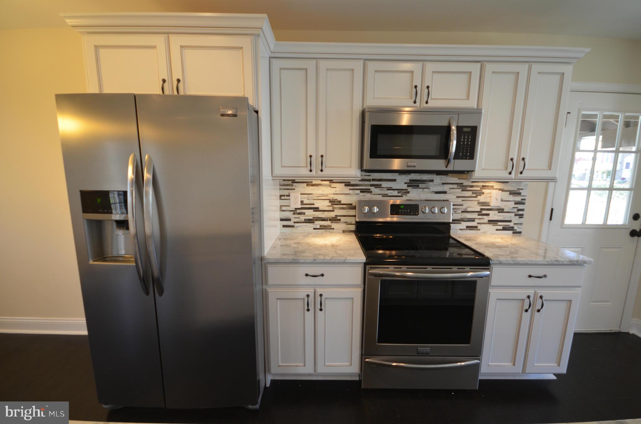 6405 Darwin Road Laurel, MD 20707 - Photo 3 of 20 a kitchen with a refrigerator stove and microwave