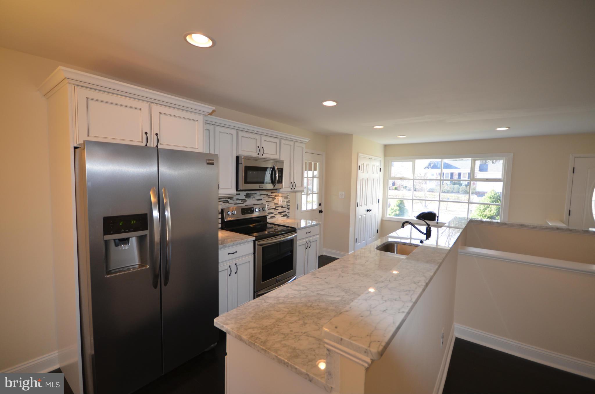 6405 Darwin Road Laurel, MD 20707 - Photo 4 of 20 a kitchen with stainless steel appliances granite countertop a refrigerator a sink a stove and a refrigerator with wooden floor