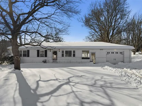 a front view of a house with a yard covered in snow