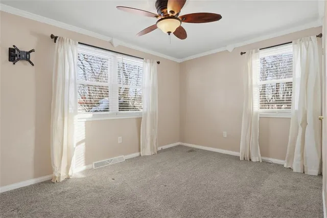 an empty room with closet and windows