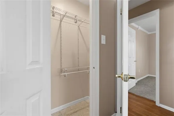 a kitchen with a stove a sink and white cabinets with wooden floor next to windows