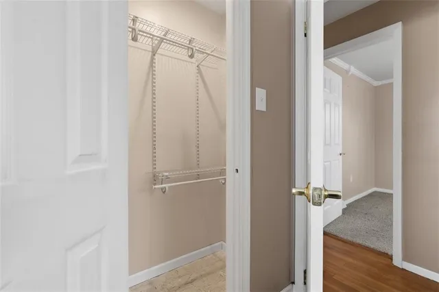 a kitchen with a stove a sink and white cabinets with wooden floor next to windows