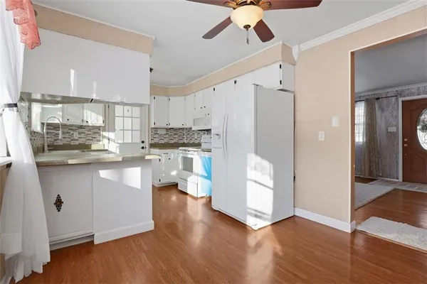 a kitchen with white cabinets and white appliances