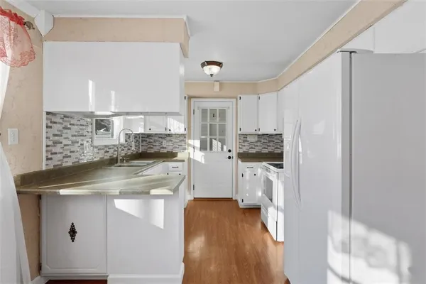 a kitchen with a sink cabinets and wooden floor