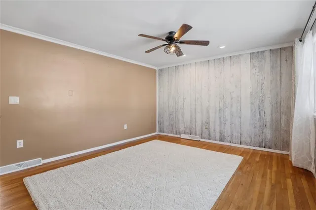 a view of a room with a wooden floor and a ceiling fan