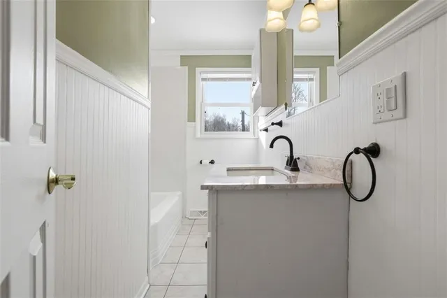 a bathroom with a sink and mirror with window