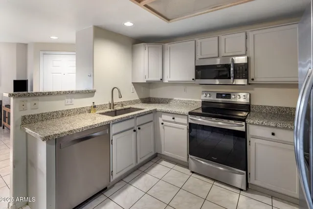 a kitchen with stainless steel appliances granite countertop a sink stove and microwave