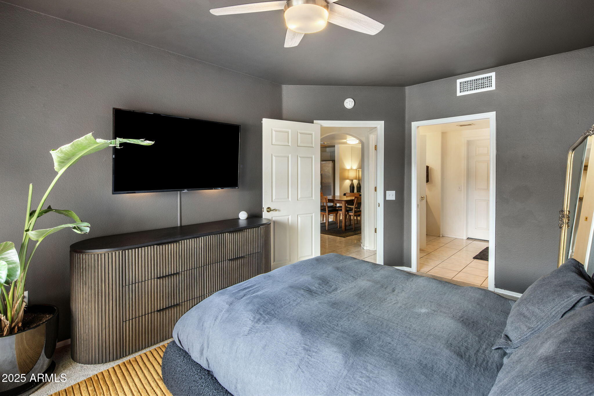 10410 North Cave Creek Road, Unit 1115 Phoenix, AZ 85020 - Photo 9 of 19 a bedroom with furniture and a flat screen tv