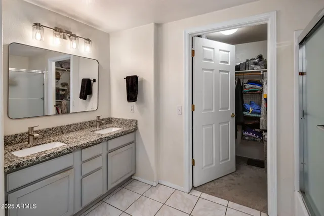 a spacious bathroom with a granite countertop sink and a mirror
