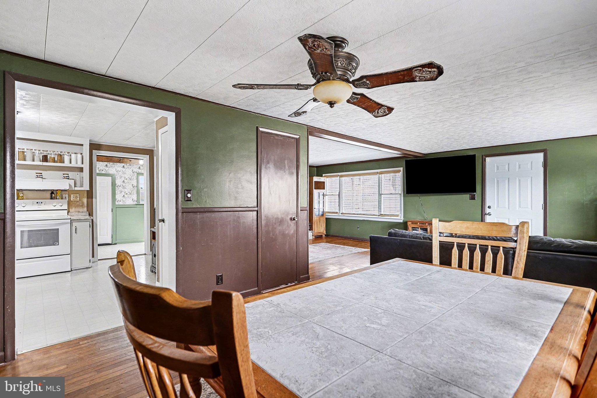 5405 West Canal Road East Berlin, PA 17316 - Photo 10 of 45 a kitchen with stainless steel appliances kitchen island granite countertop a refrigerator a stove a sink a dining table and chairs with wooden floor