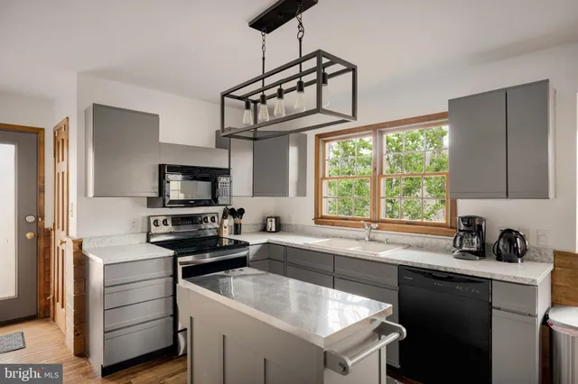 a kitchen with a sink cabinets stainless steel appliances and a window