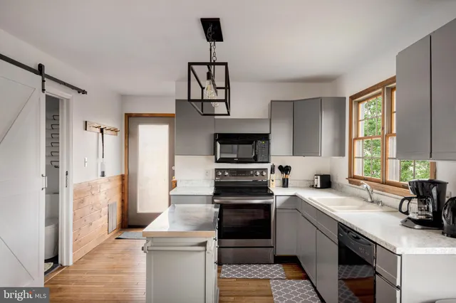 a kitchen with cabinets stainless steel appliances a sink and a window