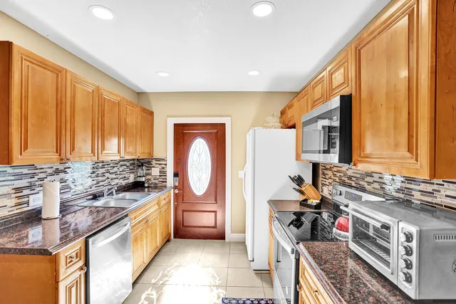 a kitchen with stainless steel appliances granite countertop a stove a sink and a refrigerator