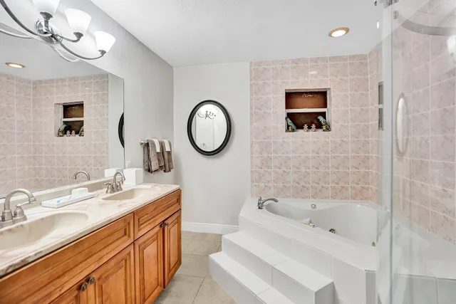 a bathroom with a bathtub sink mirror and vanity