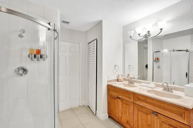 a bathroom with a double vanity sink mirror and shower