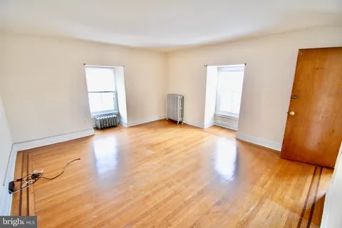 an empty room with wooden floor and a window