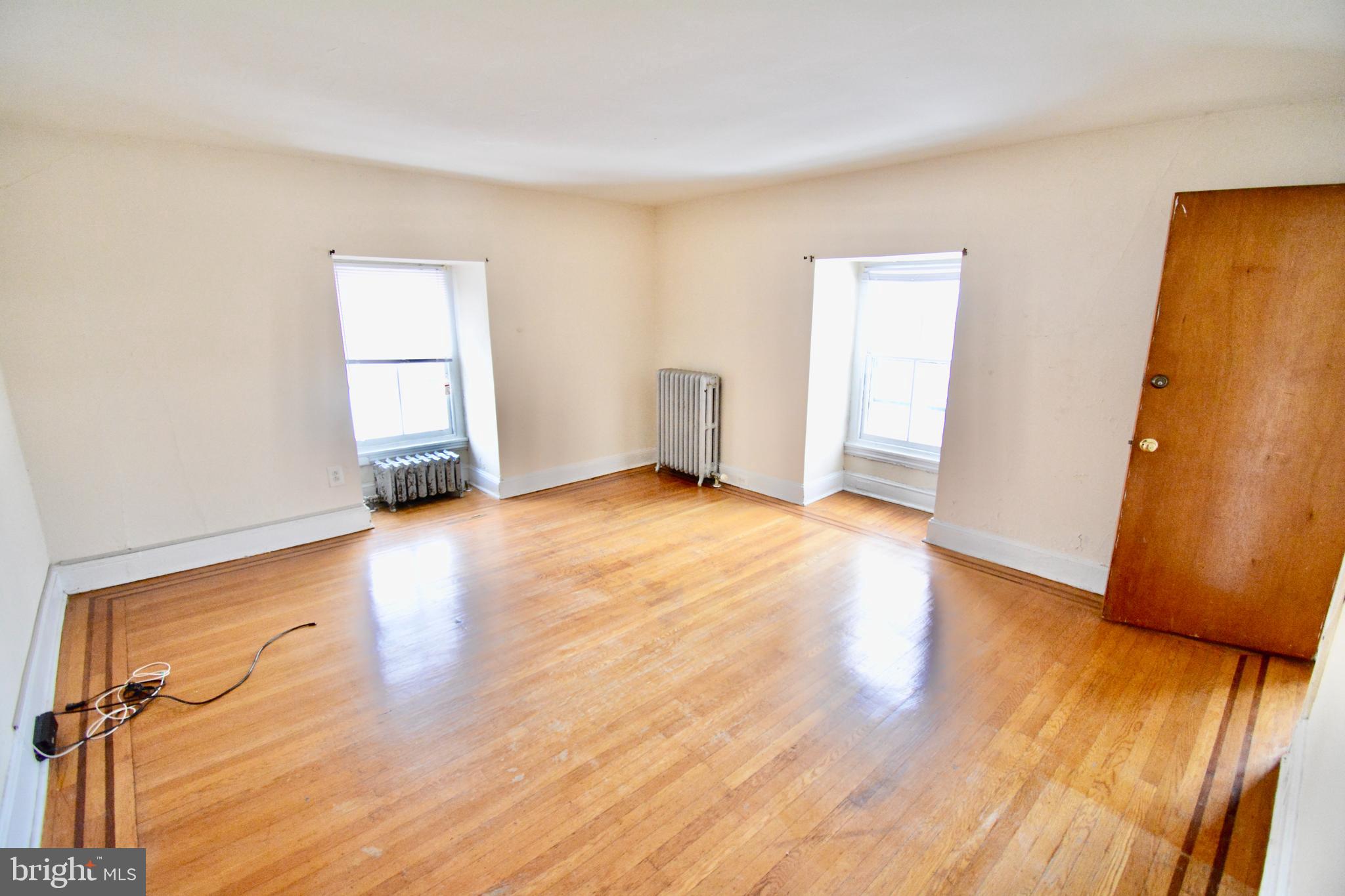 38 West Seymour Street, Unit 3 Philadelphia, PA 19144 - Photo 2 of 11 an empty room with wooden floor and a window