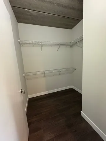 a view of walk in closet with empty racks