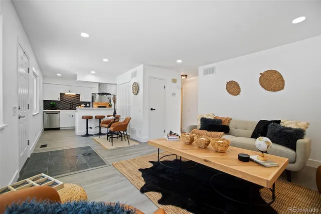 a living room with lots of furniture and view of kitchen