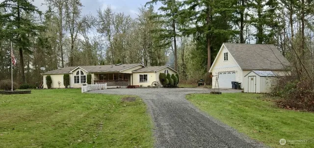 a view of a house with backyard and trees