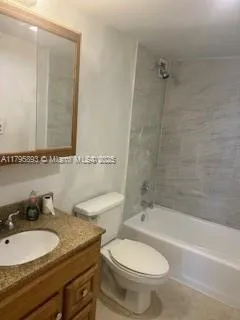 a bathroom with a granite countertop toilet a sink and a bathtub
