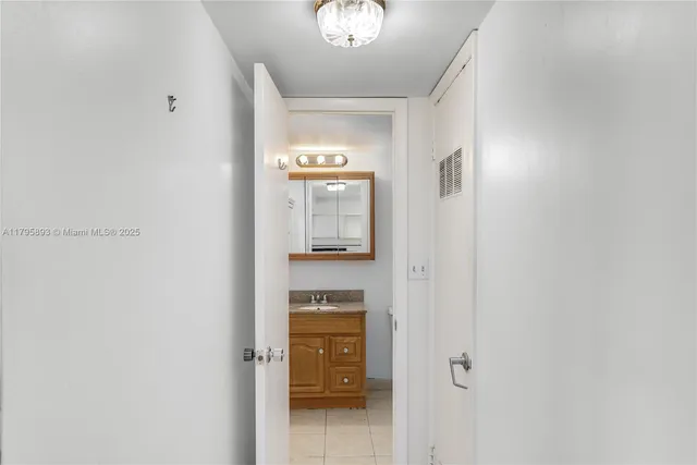 a view of a hallway with wooden floor and a bathroom