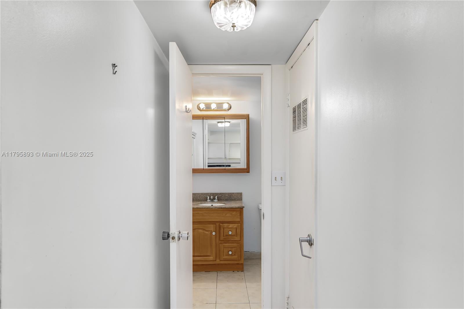 345 Ocean Drive, Unit 904 Miami Beach, FL 33139 - Photo 14 of 36 a view of a hallway with wooden floor and a bathroom