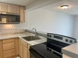 a view of a kitchen with a sink and cabinets