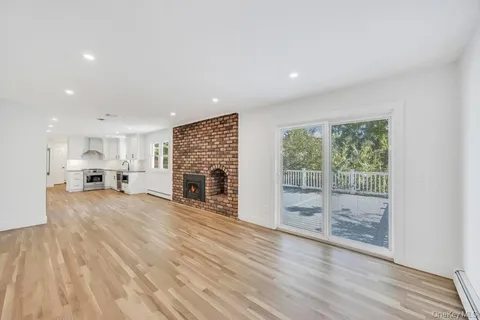 a view of empty room with wooden floor and fireplace