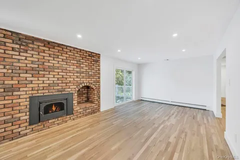 a view of empty room with wooden floor and fireplace