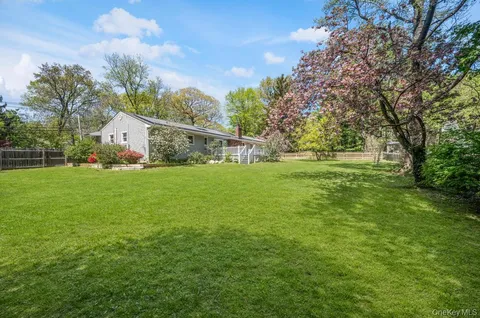 a front view of a house with garden and trees