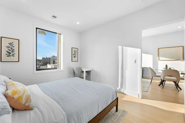 a bedroom with a bed and wooden floor